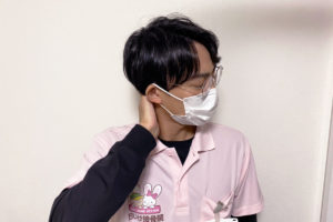 寝違えで首を抑えている